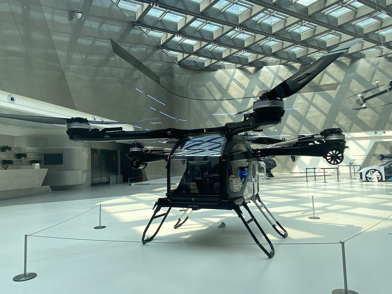The Land Aircraft Carrier's detachable two-seat eVTOL aircraft with folding rotors, ARIDGE branding on its frame.