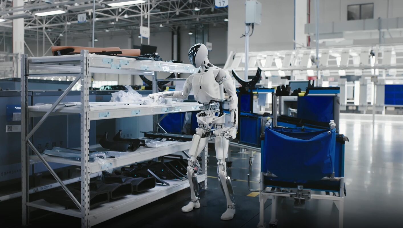 Humanoid robot picking parts from a rack on an electric vehicle production line in Guangzhou.